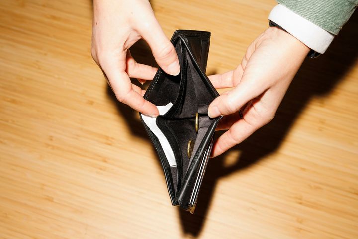 Two hands opening an empty black wallet