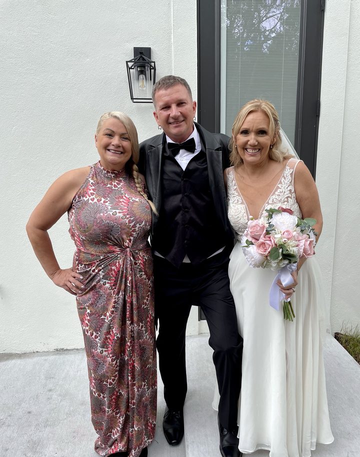 Karin with a smiling couple outside the venue after their ceremony